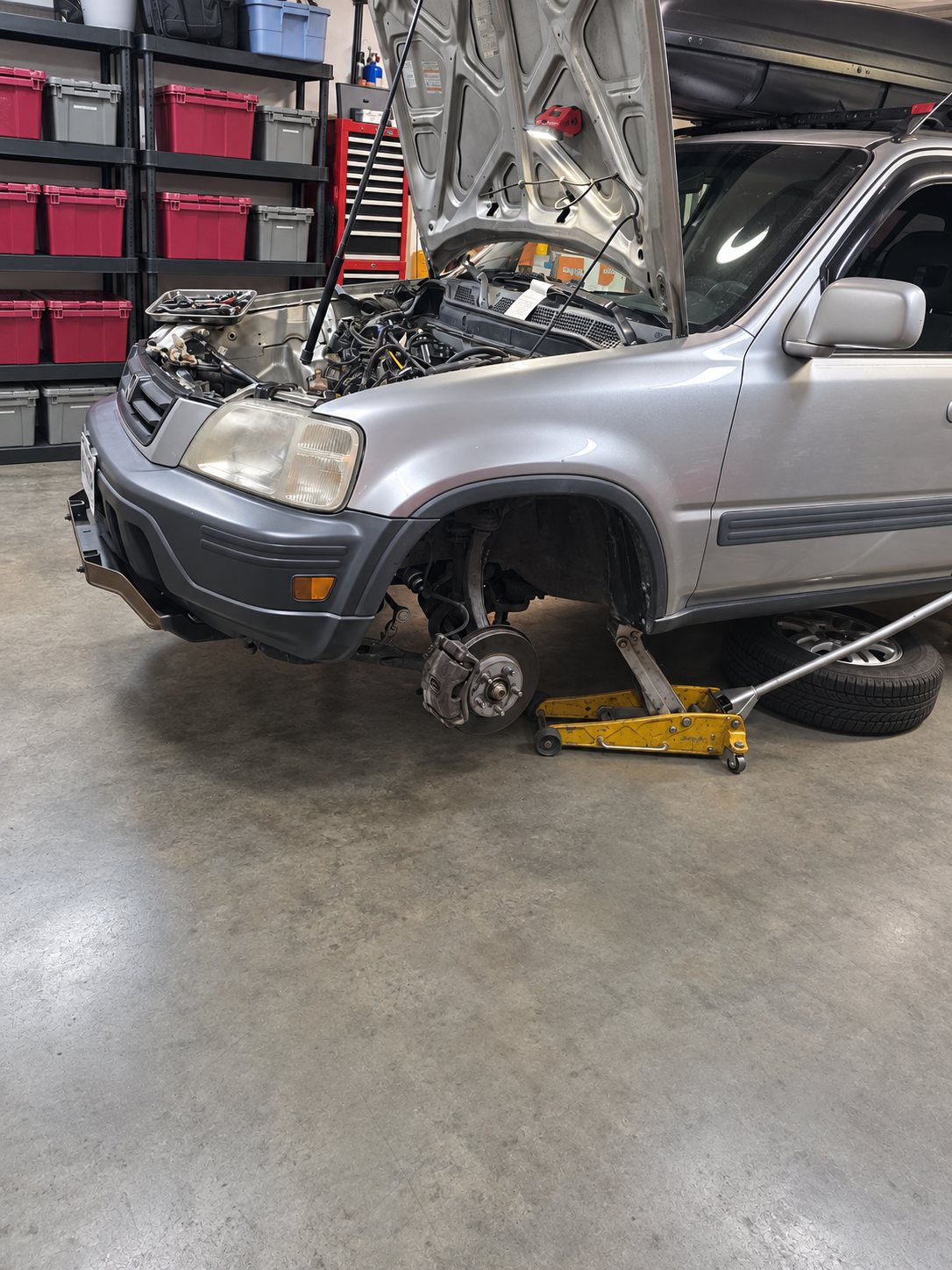 Honda CR-V on a jack with the wheel off for brake work