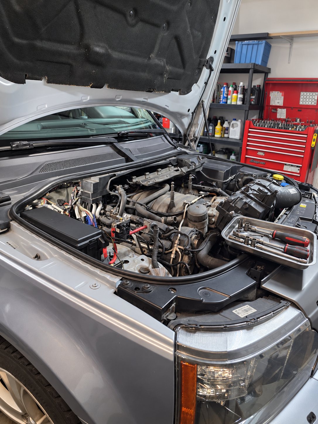 Engine bay open with tools laid out during a service